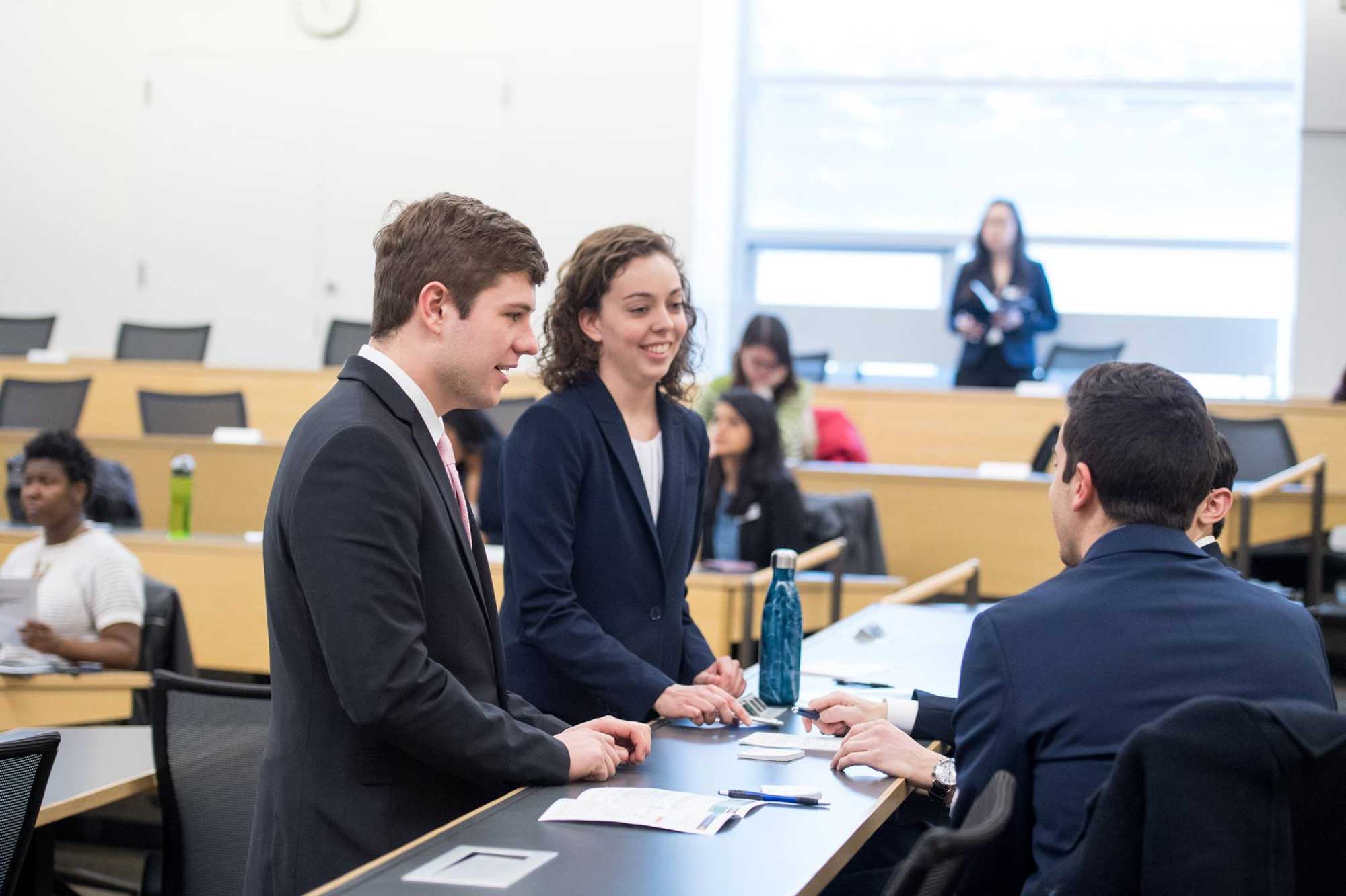 Nick Walsh, left, and Brie Riley, both juniors at the University of Michigan Ross School of Business, confer with other members of team Upstart during the Social Impact Challenge competition finals on Feb. 6, 2018. The team won $3,000 for their ideas to spur pop-up businesses in Detroit neighborhoods. Image credit: Michigan Photography