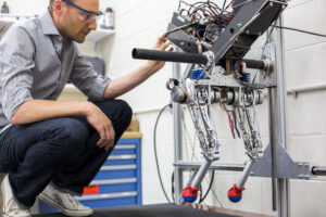 David Remy, ME Professor, works in the Robotics and Motion Laboratory (RAMLab) in the GG Brown Building, testing the research group's new robot, Ramone, on May 27, 2014.