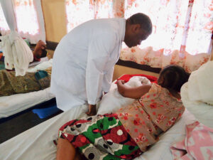 Dr. Denis Mukwege conducting rounds in the fistula ward and visiting a patient her bedside.