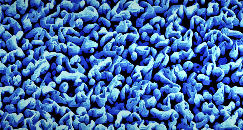 The colorized electron microscope image shows the gallium nitride towers of the artificial photosynthesis device at 25k magnification. These nanostructures rip water molecules apart into hydrogen and oxygen to produce clean hydrogen fuel. Image credit: Faqrul A. Chowdhury, McGill University