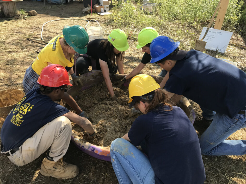 Students with Joe Trumpey's Green Building class mix adobe for the straw bale building they built on the U-M Campus Farm at the Matthaei Botanical Gardens. Trumpey is an associate professor at the Penny W. Stamps School of Art & Design and professor at the U-M School for Environment and Sustainability.
