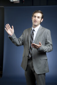 Kyle with hand out speaking