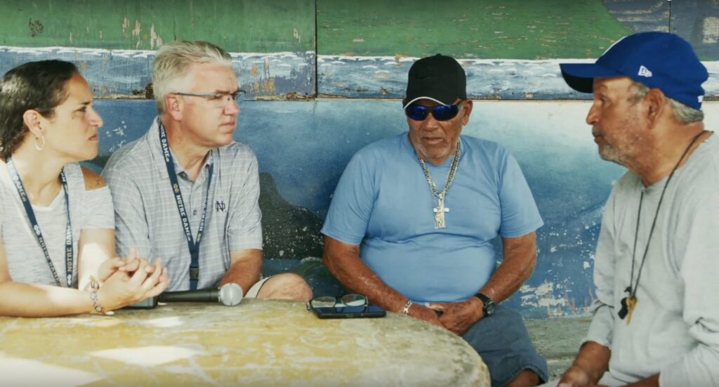 University of Notre Dame faculty, Marisel Moreno and Thomas Anderson, speak with two Puerto Rican men about their experiences with Hurricane Maria.