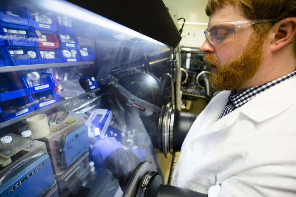 Nathan Taylor, a post-doctoral fellow in mechanical engineering, inspects a piece of lithium metal in the Phoenix Memorial Laboratory building. Image credit: Evan Dougherty, Michigan Engineering