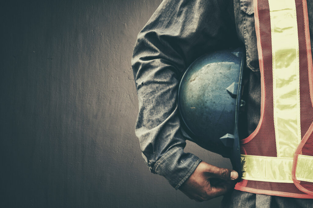 Man holding blue helmet close up. Image credit: iStock