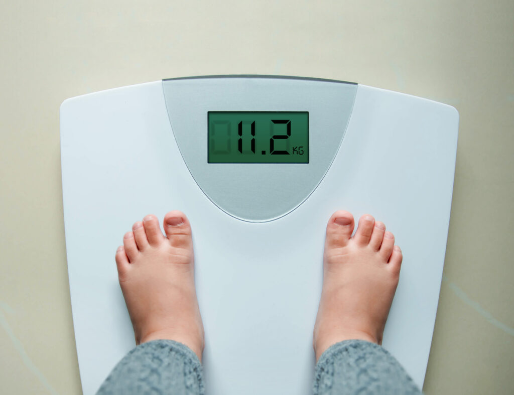 Healthy weight gain for baby or children concept photo of a toddler standing on a scale. (iStock photo)