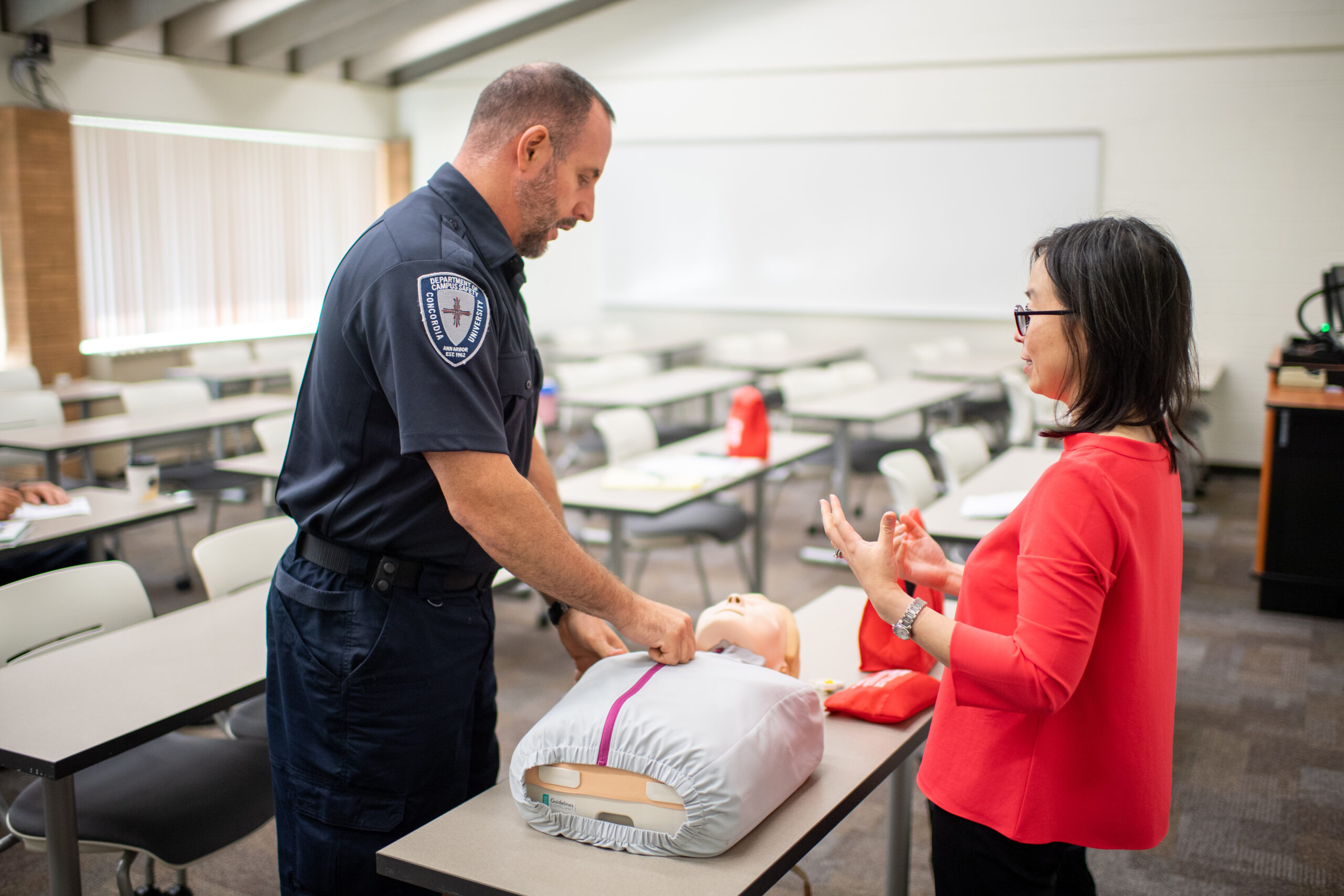 Chin Hwa (Gina) Dahlem discusses overdose treatment with Christopher Imperati, assistant campus safety director at Concordia University. Image credit: Chris McElroy, Michigan Photography