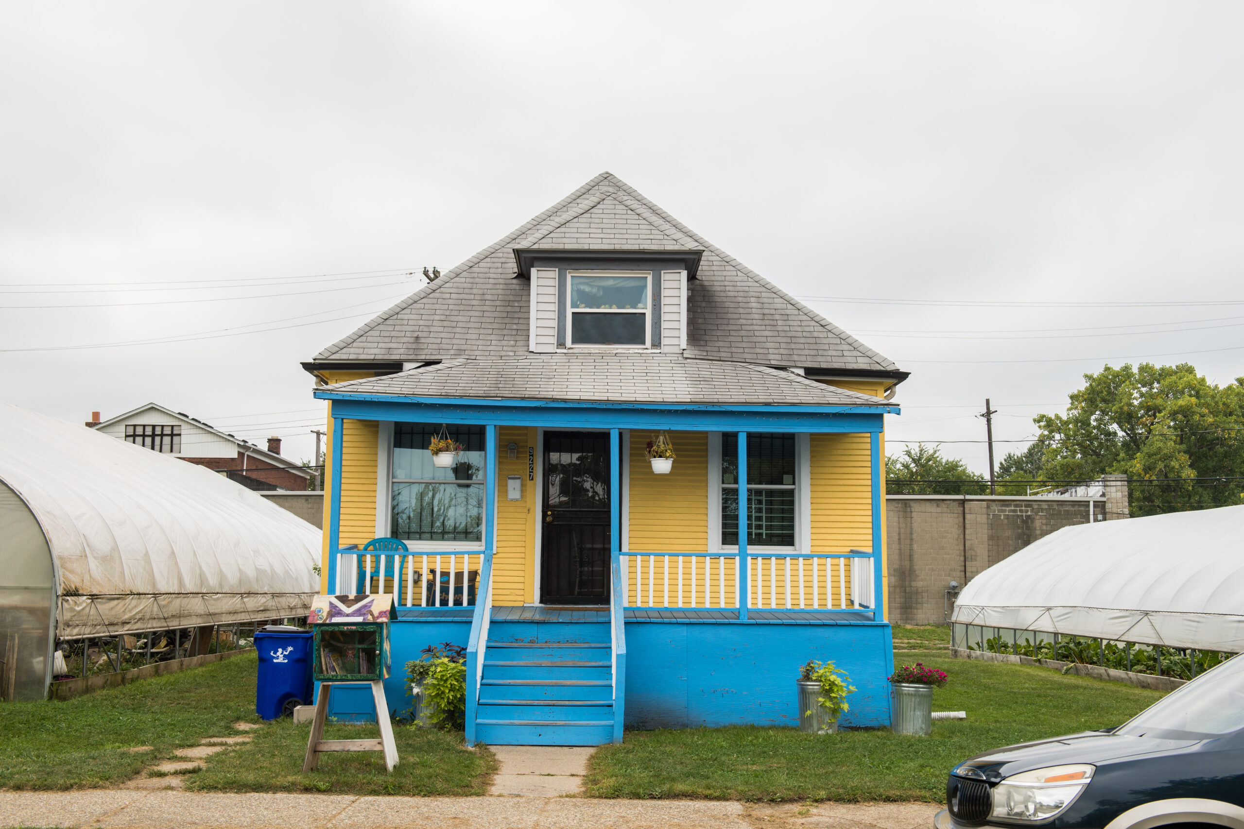 Two greenhouses filled with vegetables sprout alongside the Oakland Avenue Urban Farm’s Community House in Detroit. The 10-year-old, six-acre farm was founded by Jerry Hebron to be a stabilizing presence in the neighborhood and a much-needed source for fresh food, and it has been both. The farm and its "Yellow House" headquarters have become a sort of commons and a regular meeting place for different community groups. Image credit" Michigan Photography