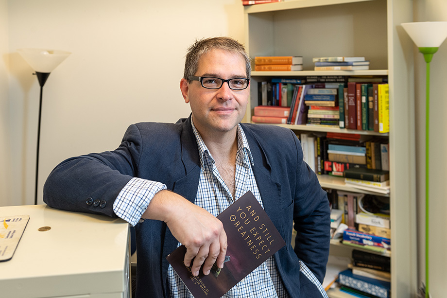 Photo of Phil Christman standing in his office
