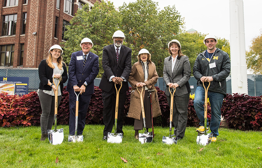 Photo of people digging first shoveful at groundbreaking for Kraus building