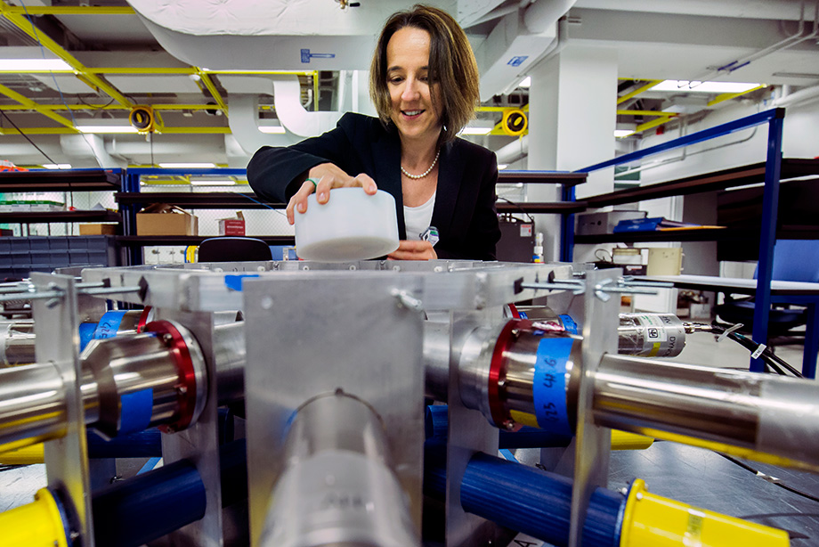 Photo of Sara Pozzi putting a radioactive sample into an array of detectors