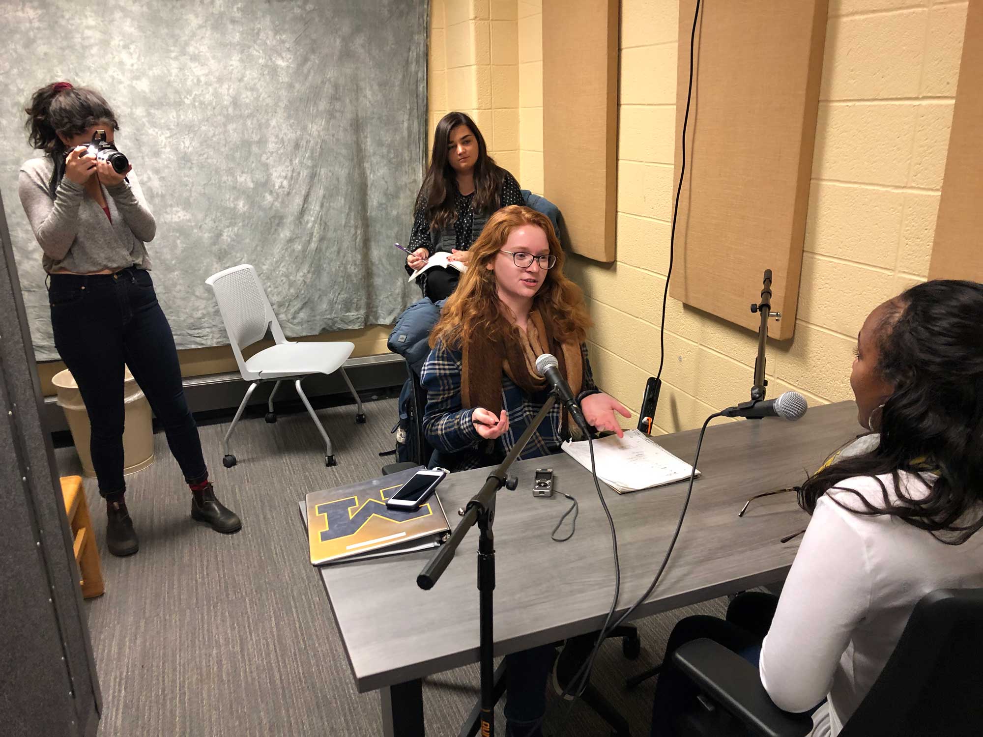 Hannah French interviews Asia Johnson while Zoey Horowitz shoots photos and Megan Diebboll takes notes.
