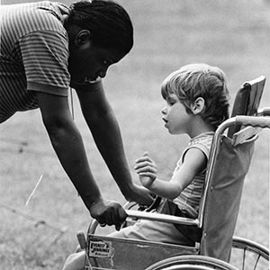 Boy in wheelchair with counselor.
