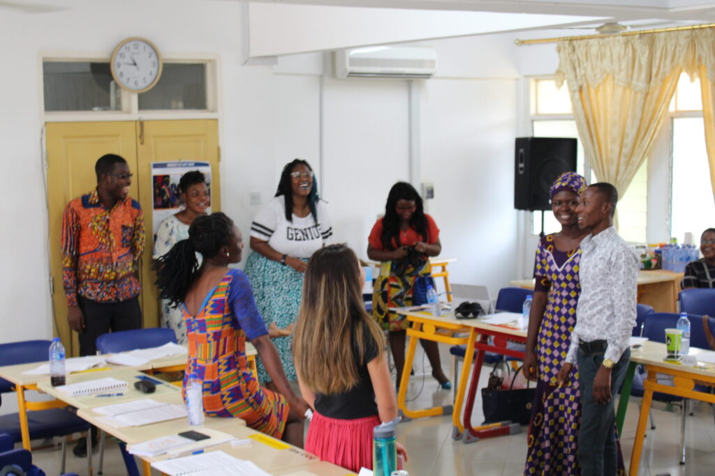 University of Michigan student Briana Sanders answers questions and laughs with students from the University of Cape Coast about her sexual health jeopardy game. Image courtesy: U-M School of Nursing