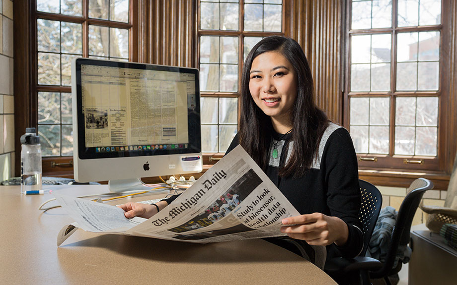 Photo of Ashley Tjhung reading a newspaper