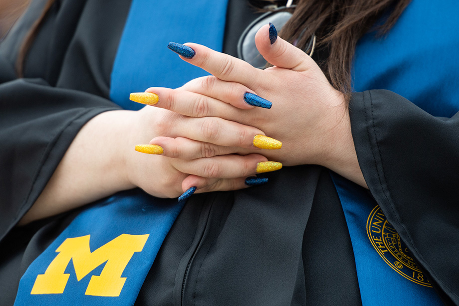 Photo of graduate with maize-and-blue fingernals