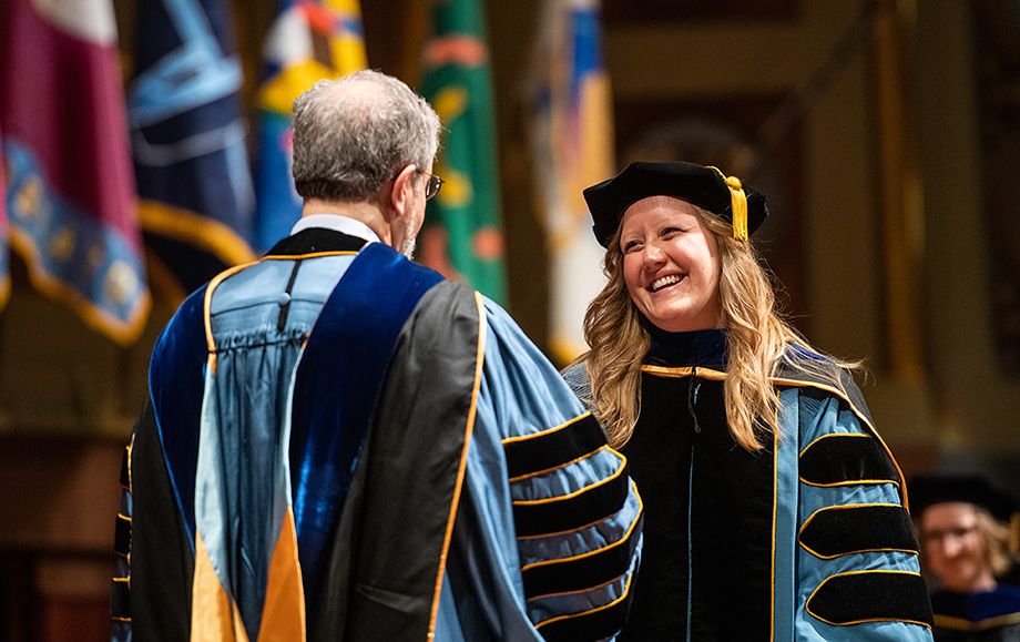 Photo of graduate being congratulated by President Schlissel