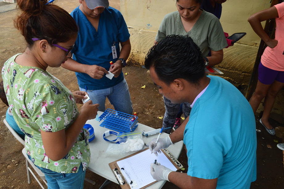 Photo of study personnel preparing to collect blood samples from children in a neighborhood in Managua in June 2017