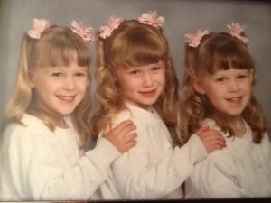 Three kid triplets in matching outfits.