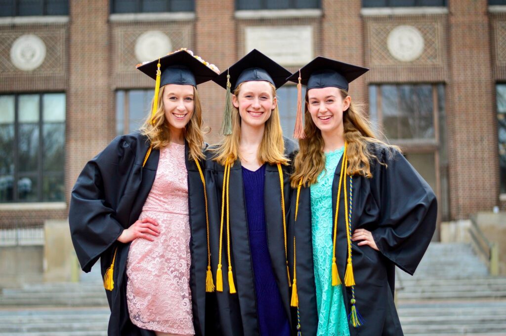 Three sisters in graduation caps and gowns.