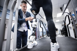 Elliott Rouse, Assistant Professor of Mechanical Engineering, runs tests on an open-source robotic leg with Dawn Jordan Musil. Image credit: Joseph Xu, Michigan Engineering