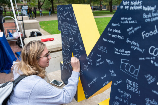 LSA student Lisbeth Rubin signs a Block M at the Michigan Union birthday celebration.