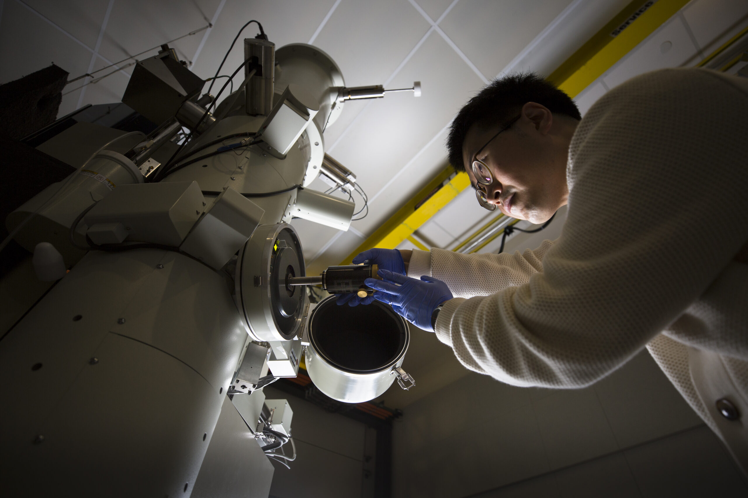 Jiseok Gim, materials science and engineering PhD candidate, demonstrates loading a sample into the JEOL 3100R05 electron microscope in the Michigan Center for Materials. Image credit: Evan Dougherty, Michigan Engineering