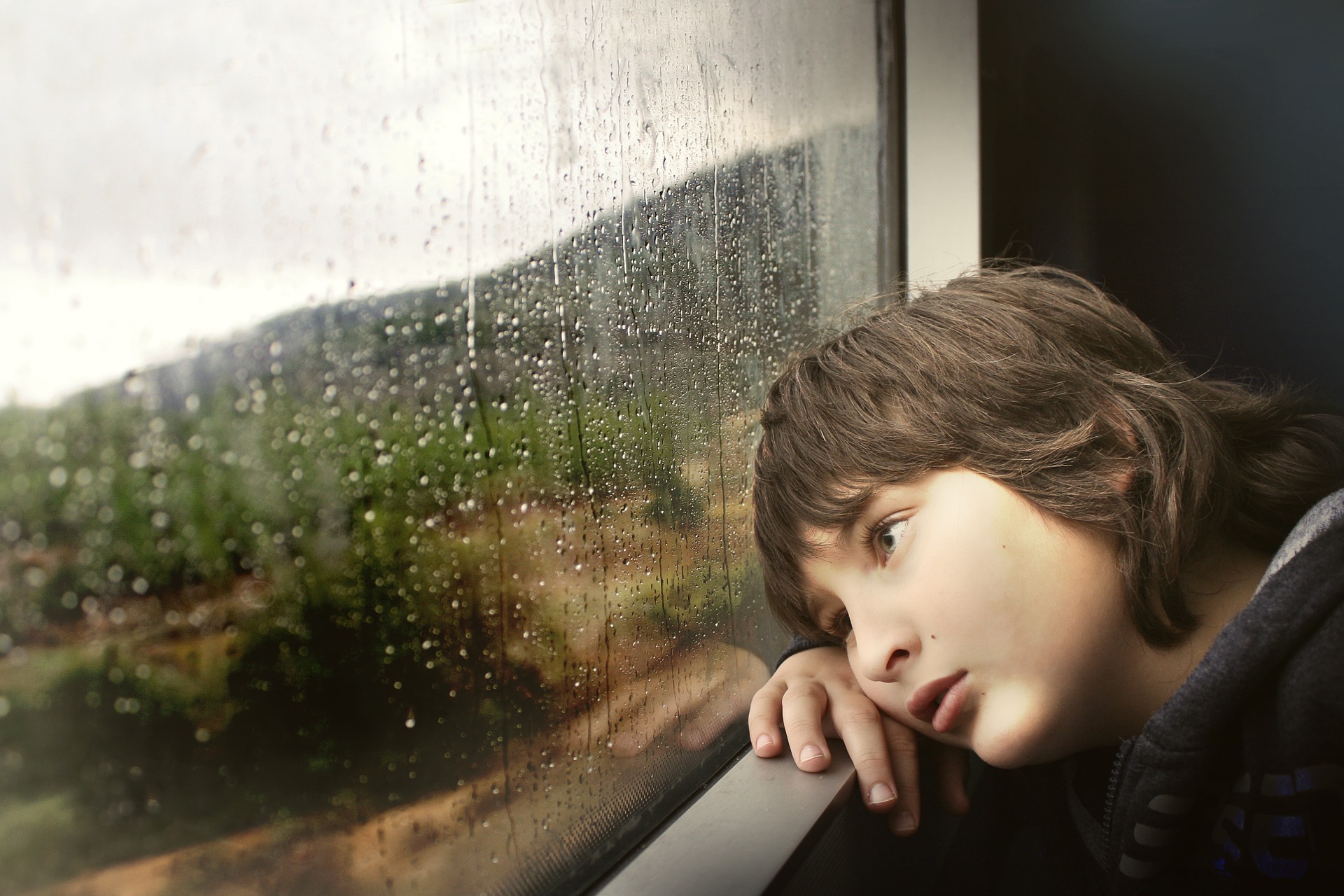 A young boy looks out a window. Image credit: Pixabay.com