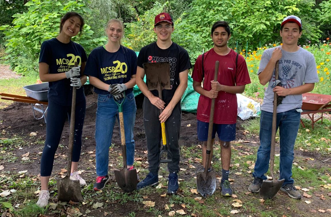 From left, Sarah Ong, Jordan Manley, Vincent Sposato, Rahul Ribiero and Josh Salenbien pose with shovels at the Growing Hope Urban Farm in Ypsilanti. All five U-M students are members of the Michigan Community Scholars Program under the umbrella of LSA. (Photo by Emily Welch)
