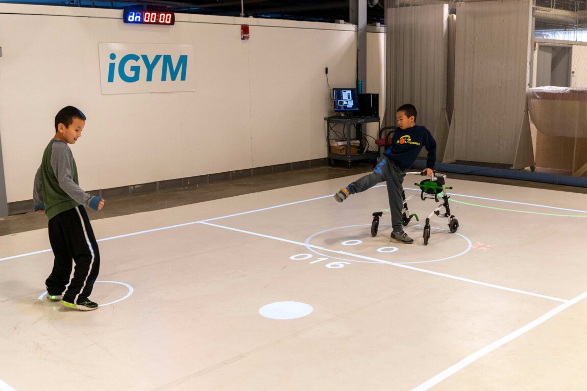 Darren Kreps (left) and his brother Bryan Kreps participate in a "play test" of iGym, an augmented reality system created by a multidisciplinary team at the University of Michigan that promotes inclusive play and exercise. 