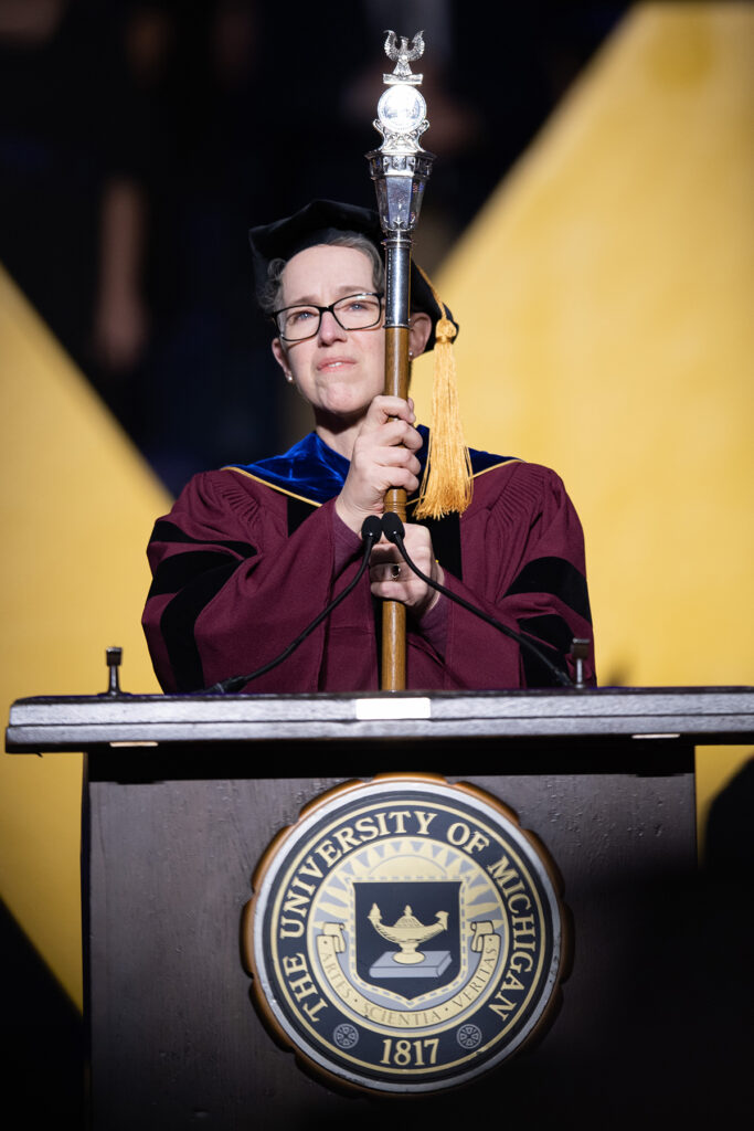 SACUA Chair Joy Beatty presents the university's mace, a symbol authority at U-M ceremonies.