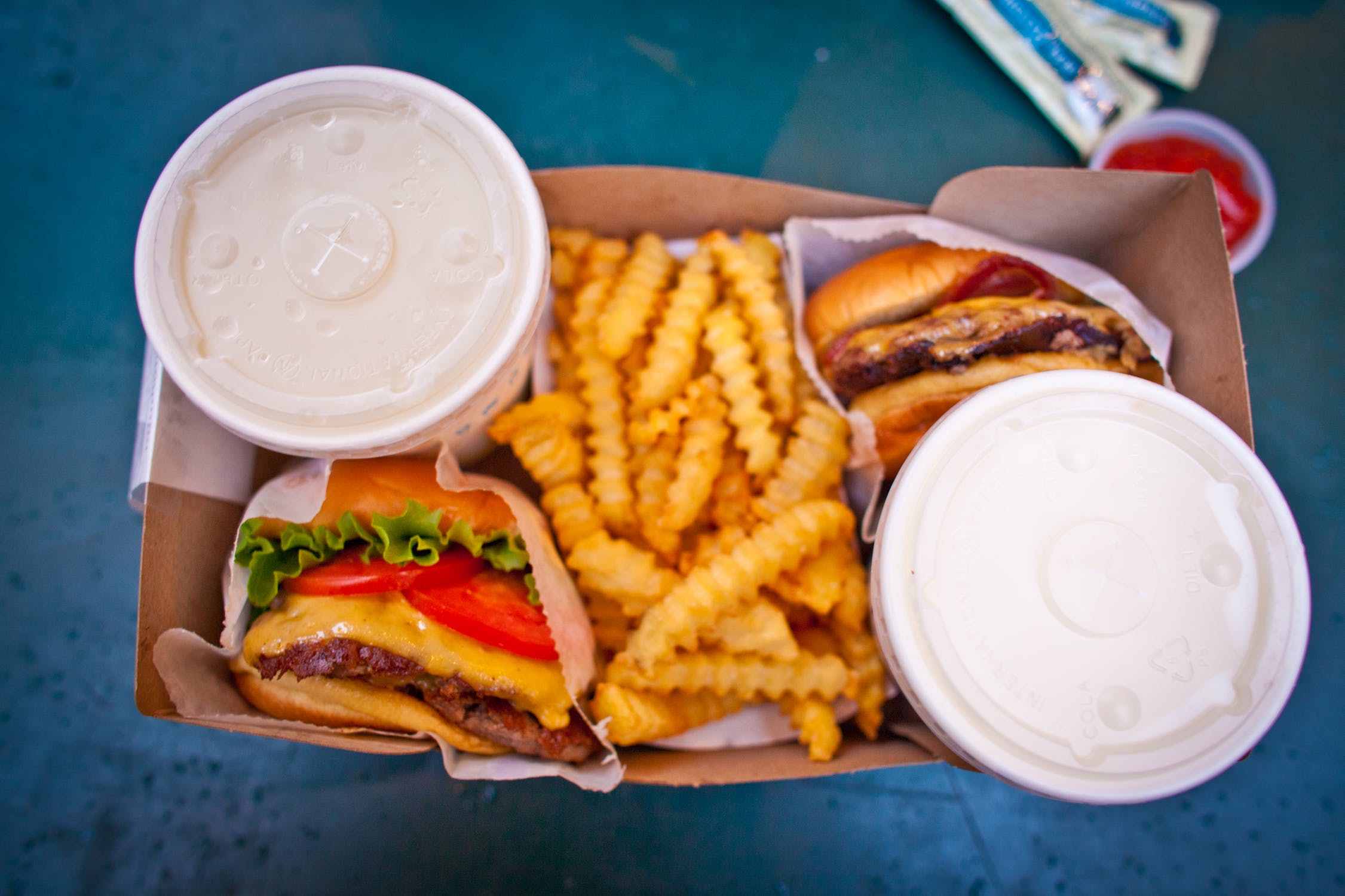 A box with burgers, fries and soda.