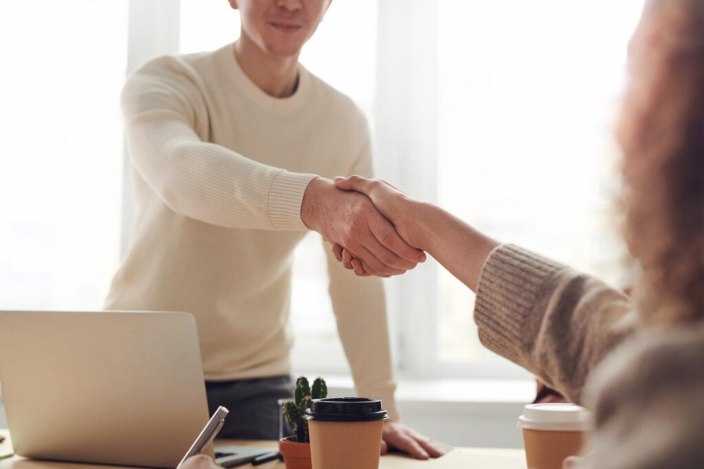 A man and woman shake hands over a desk. Image credit: Pexels.com user, fauxels