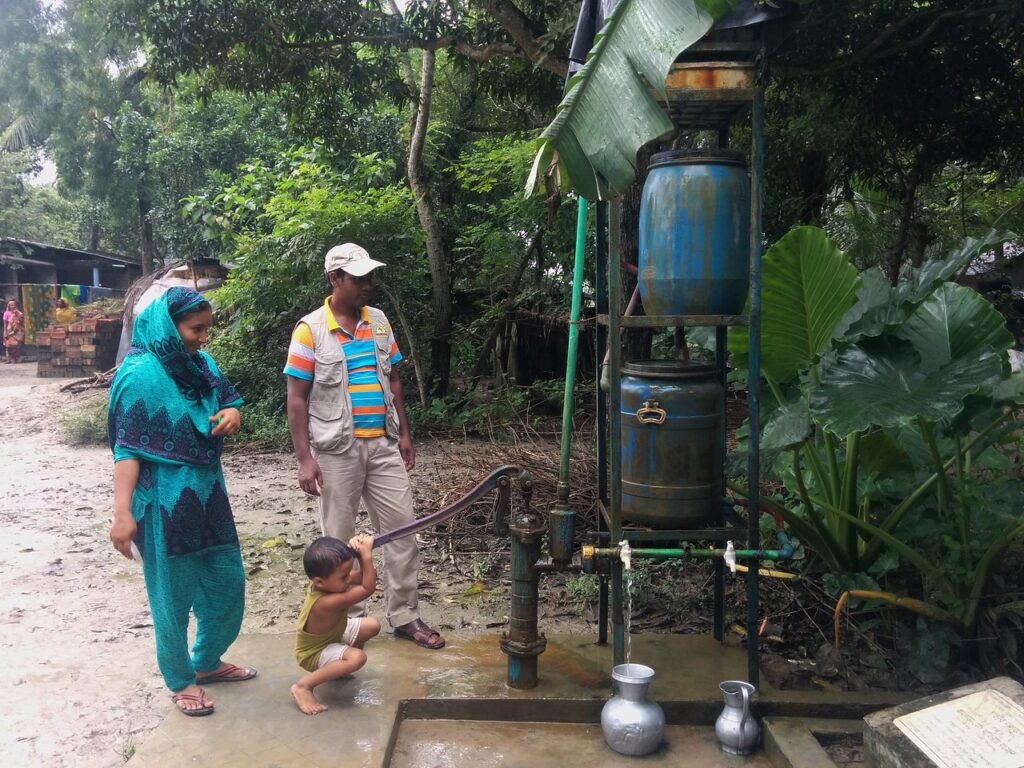 Family collecting water from a smaller community safe drinking water device. Image credit: R. Reddy