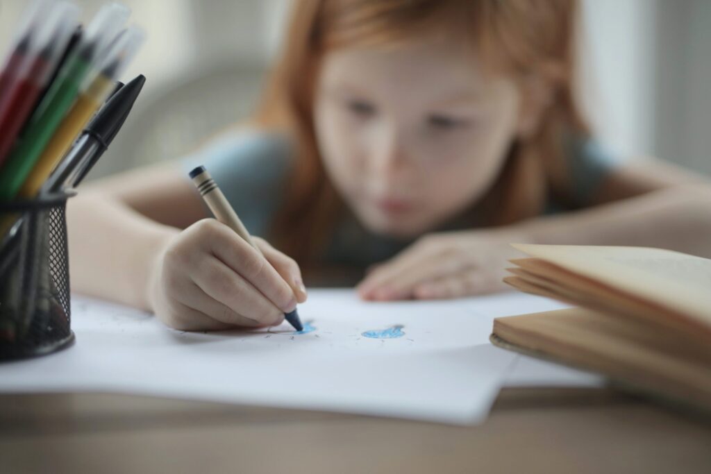 A young child using a crayon. 