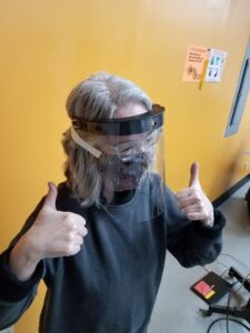 Pamela Cohen tests a face shield for fit at Maker Works. Image credit: Maker Works.