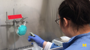 Lucinda Li, CEE PhD Student, sprays a N-95 mask with a test virus. After the spray is dried, it is sent to U-M hospitals for the sanitization tests. Image credit: Krista Wigginton and Nancy Love research group.