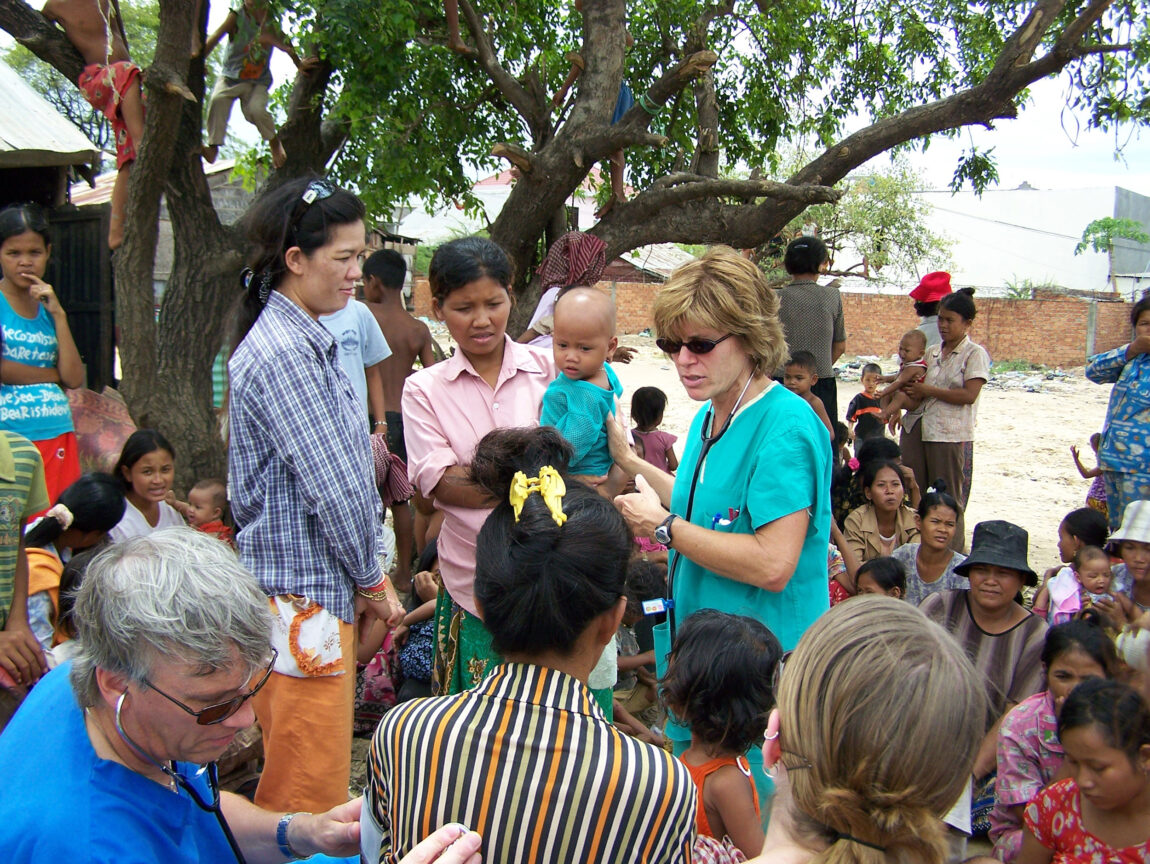 Maureen Tippen, a clinical associate professor emerita of nursing at UM-Flint and this year’s recipient of the President’s Award for Distinguished Service in International Education, works with members of a Cambodian village during a trip to that country. (Photo by Nicole Richon)
