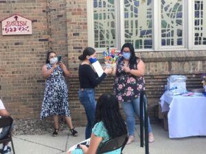 A Latinx high school grad receives a certificate of recognition from Lideres de la Comunidad in June 2020.