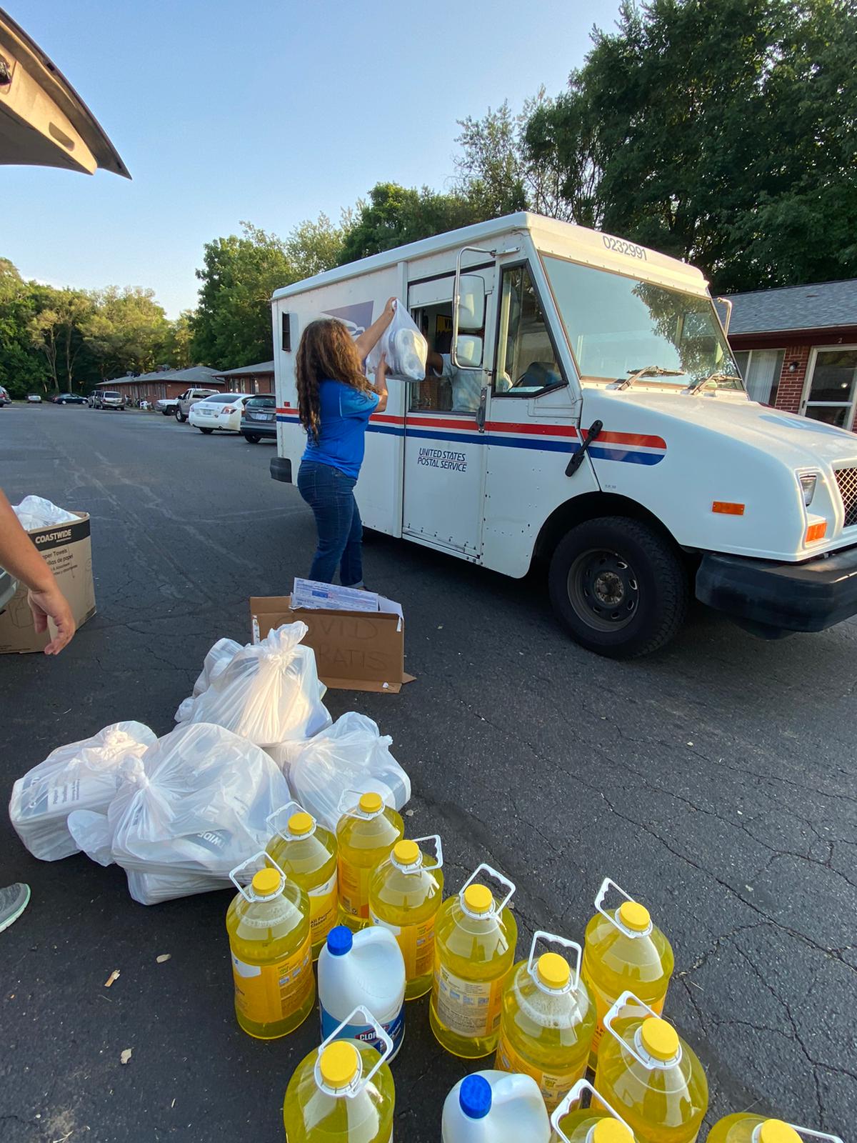 María Militzer helps distribute personal protection equipment and cleaning supplies to help community members deal with the pandemic during a recent event. Image credit: Mexiquenses en Michigan.