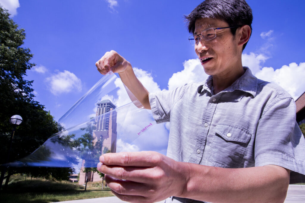 Jay Guo holds a sheet of flexible transparent conductor on the University of Michigan’s College of Engineering North Campus.