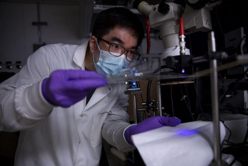 Changyeong Jeong, a graduate student in electrical engineering and computer science, measures how well light passes through a sheet of flexible transparent conductor.