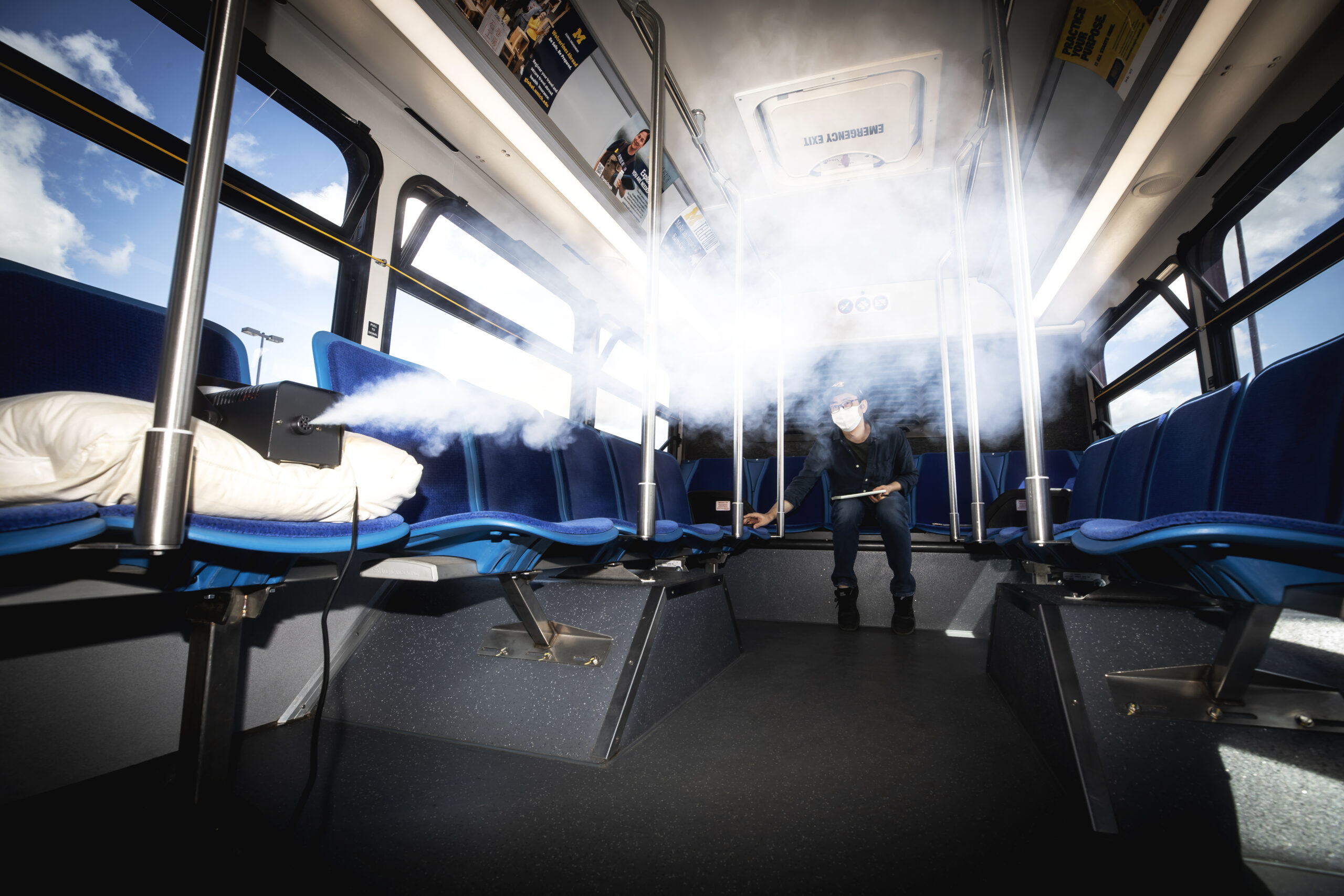 Kwang Hee Yoo, ME Researcher, measures the flow of aerosols in a University of Michigan blue bus in Ann Arbor, MI on June 24, 2020. Aerosols are liquid droplets in air that can be potential conduits for the coronavirus. A team of Michigan Engineering researchers are measuring and modeling the concentration and dispersion of aerosols in buses in order to learn how to better filter them and keep users safe. Image credit: Joseph Xu/Michigan Engineering, Communications & Marketing