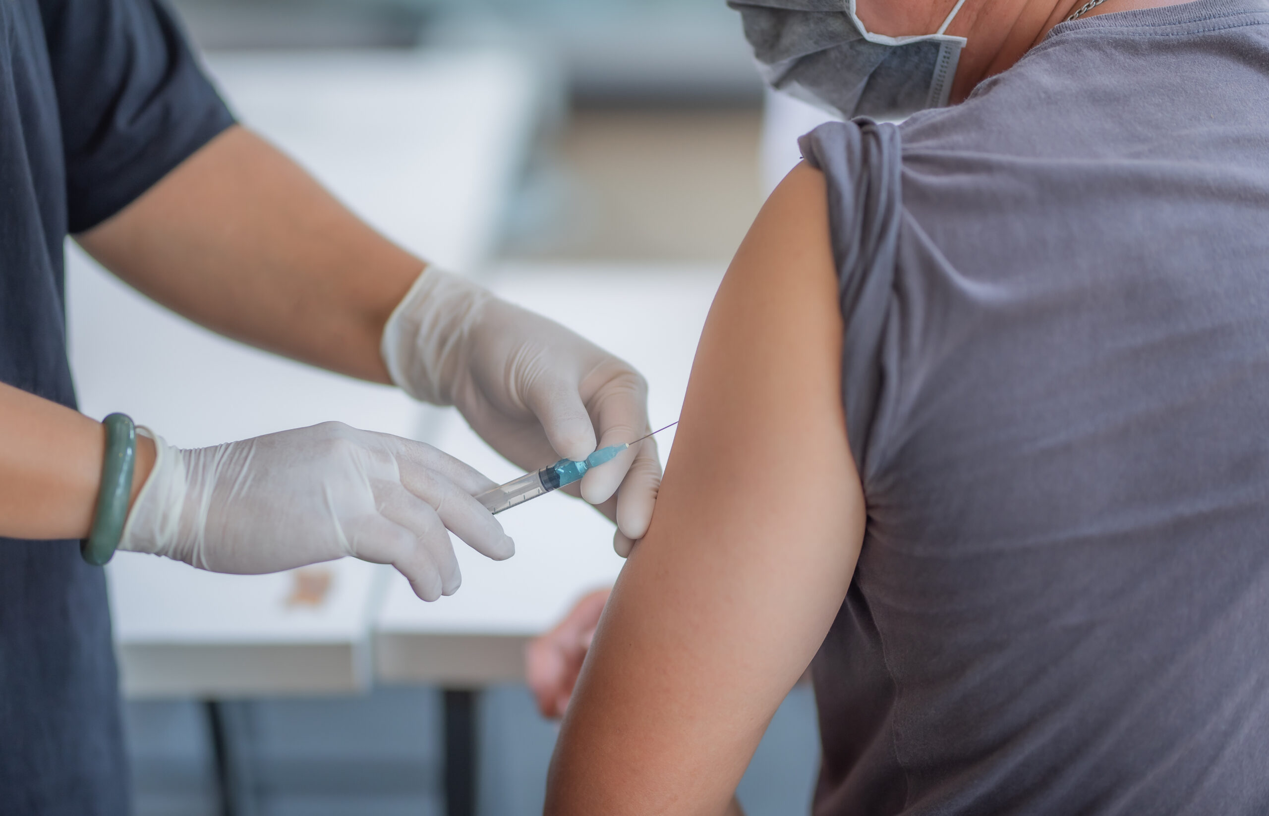 The doctor is injecting male patients.In the medical's hand have syringes. Image credit: iStock