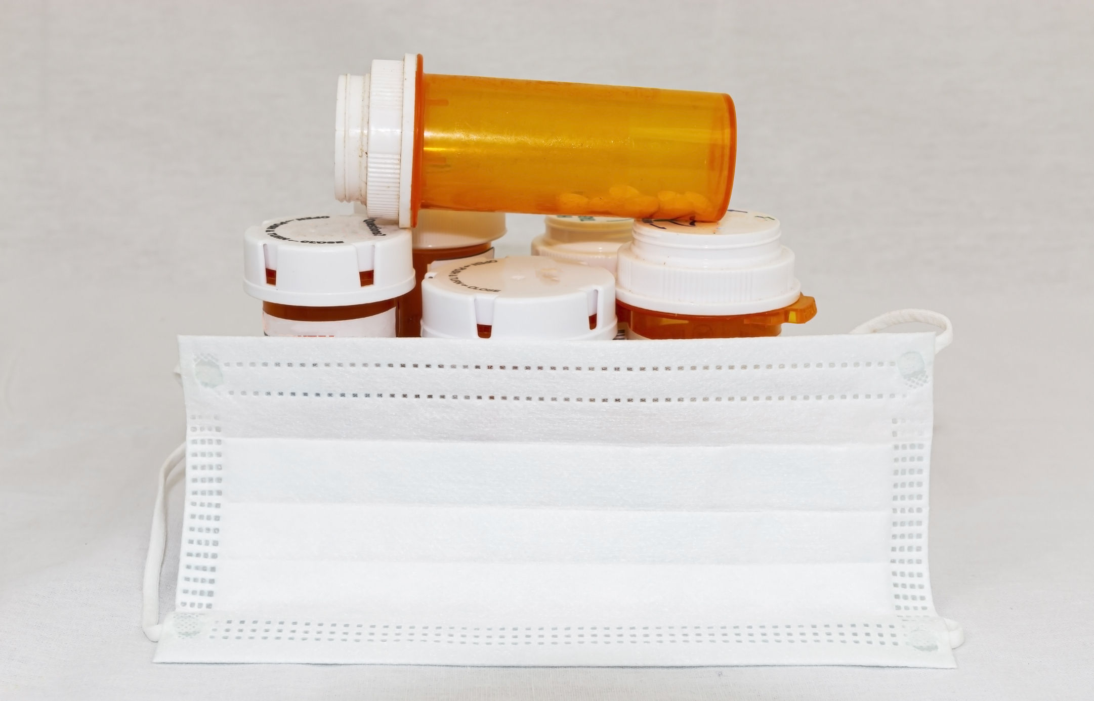 Pill bottles and a face mask. Image credit: iStock