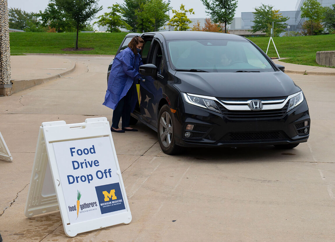 Marlene Woodard of the Department of Obstetrics and Gynecology, a staff volunteer from Michigan Medicine, assists a donor with contactless donation of food and toiletries Sept. 9 at North Campus Research Complex. (Photo by Chris Hedley, Michigan Medicine Department of Communication)