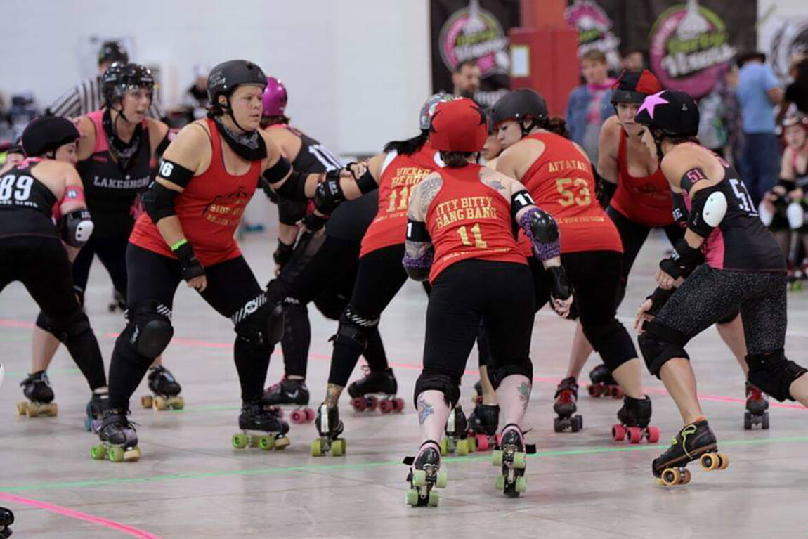 Devon Kinney, third from left, blocks in a Quad County Roller Derby match. Kinney said she prefers blocking to either jamming or being the pivot. (Photo courtesy of Soul Collector/DeFord Designs)