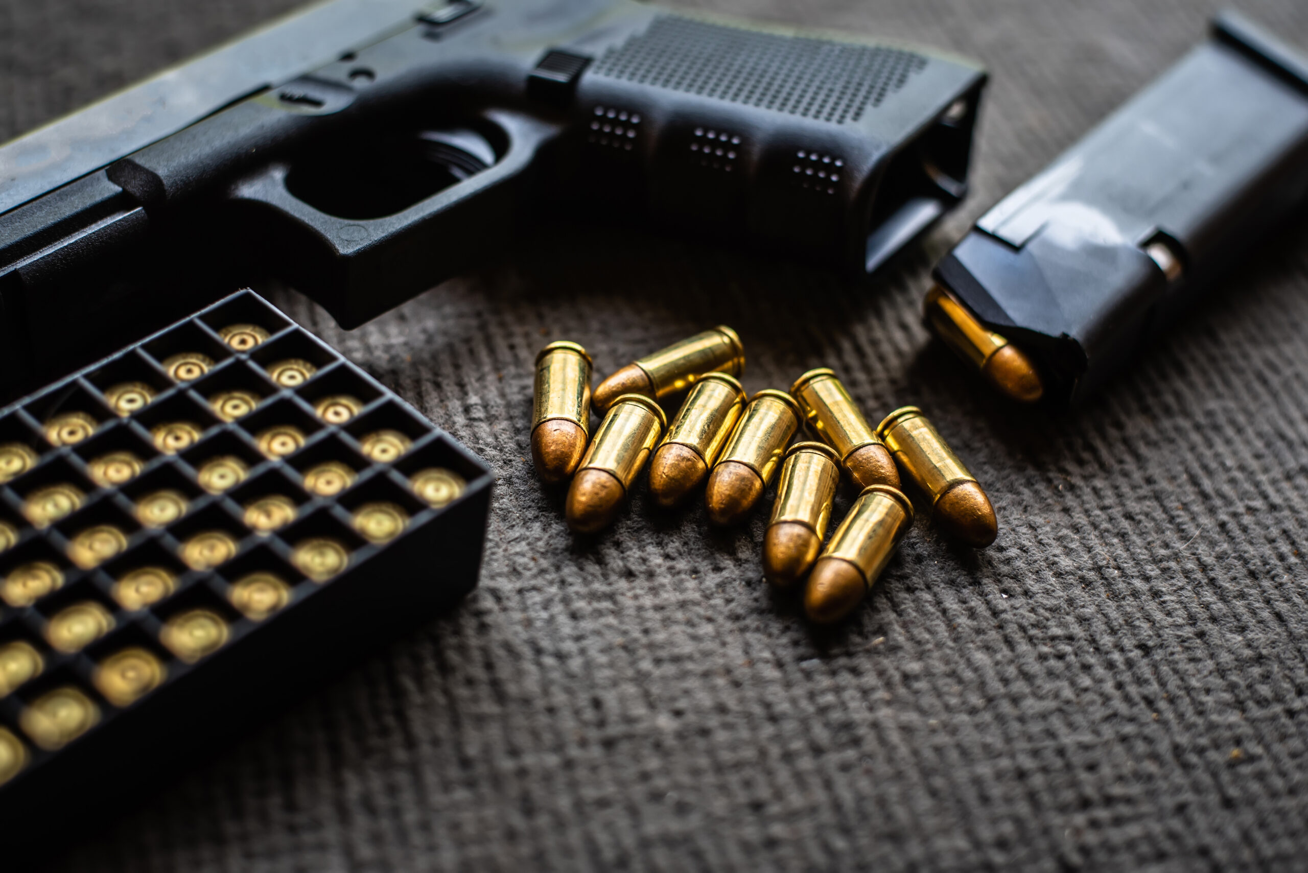 bullets and gun on black velvet desk. Image credit: iStock