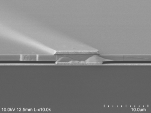 The electron microscope image shows the air (darkest gray) sandwiched between the gold backing at the bottom and the semiconductor at the top, supported on gold beams. Image credit: Dejiu Fan, U-M Optoelectronic Components and Materials Group