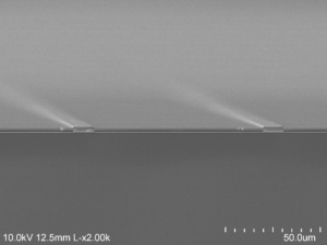 The electron microscope image shows the air (darkest gray) sandwiched between the gold backing at the bottom and the semiconductor at the top, supported on gold beams. Image credit: Dejiu Fan, Optoelectronic Components and Materials Group, University of Michigan